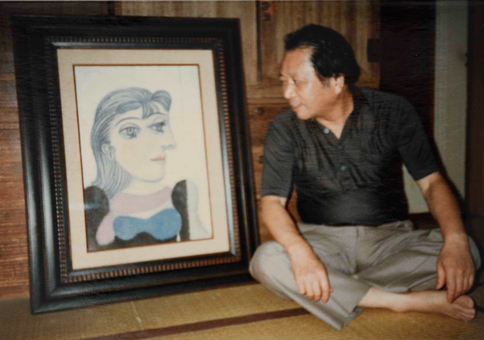 Kazuhiko sitting next to Picasso's painting in ogikubo